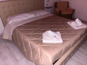 a bed with two towels sitting on top of it at Il piccolo tempio di Ely in Termoli