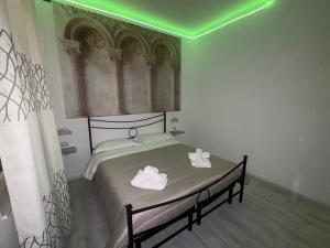 a bedroom with a bed with a green light at Il piccolo tempio di Ely in Termoli