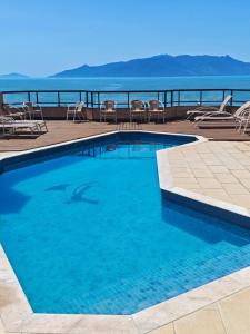a swimming pool with a dolphin in the water at Flats Beira Mar in Caraguatatuba