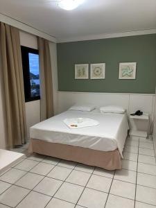 a bedroom with a bed and a window at Flats Beira Mar in Caraguatatuba