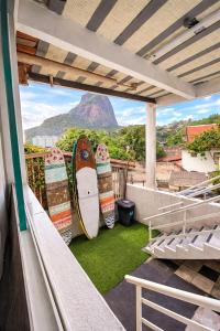 a balcony with a surfboard sitting on the grass at Suites Quebra Mar in Rio de Janeiro +17 photos