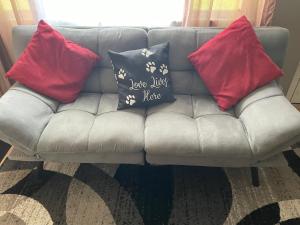a grey couch with four pillows on it at Private king suite in Dubuque +2 photos