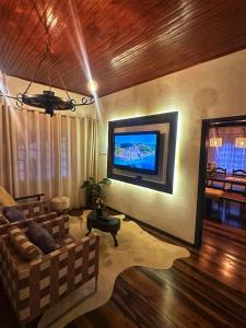 a living room with a couch and a flat screen tv at Sítio Nono Luiz in Benedito Novo