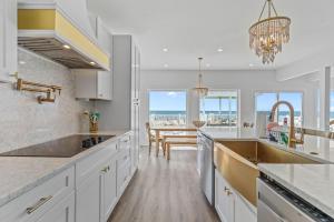 a kitchen with white cabinets and a view of the ocean at Oceanfront Luxury Private Steps to Beach New in Oak Island +49 photos