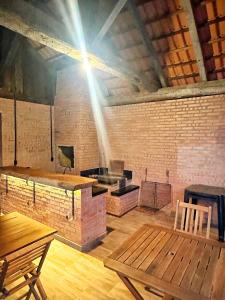 a room with a brick wall and a table and benches at Sítio Nono Luiz in Benedito Novo +19 photos
