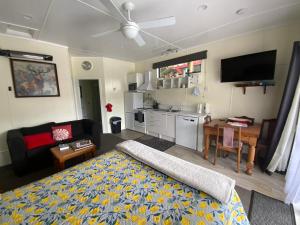 a living room with a bed and a kitchen at Union Street Hideaway in Waihi