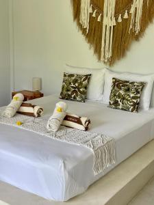 a white bed with white sheets and pillows on it at Alma Nusa Penida in Nusa Penida