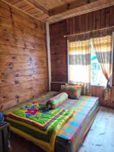 a large bed in a room with wooden walls at Serenity homestay in Mamasa