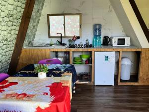 a small kitchen with a bed and a refrigerator at Hospedaje henua roa 2 in Hanga Roa