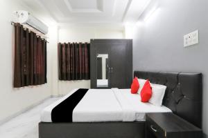 a bedroom with a black and white bed with red pillows at Hotel O Figtree Premier in Patna