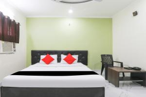 a bedroom with a bed and a chair and a desk at Hotel O Figtree Premier in Patna +39 photos