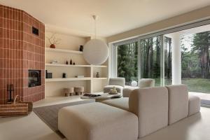 a living room with a couch and a large window at Forest Hub Popowo in Huta Podgórna