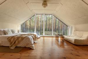 a bedroom with a bed and a large window at Forest Hub Popowo in Huta Podgórna