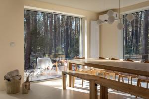 a dining room with a table and a large window at Forest Hub Popowo in Huta Podgórna