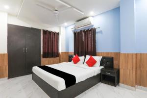 a bedroom with a bed with red pillows at Hotel O Figtree Premier in Patna