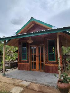 a small wooden house with a porch at Serenity homestay in Mamasa