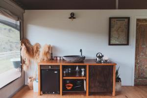 a kitchen with a sink in a room with a window at Te Awa Glamping in Taumarunui