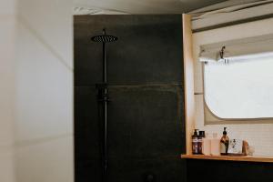 a black shower door in a bathroom with a window at Te Awa Glamping in Taumarunui