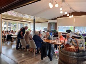 a group of people sitting at tables in a restaurant at OMARU FARM STAY in Ventnor