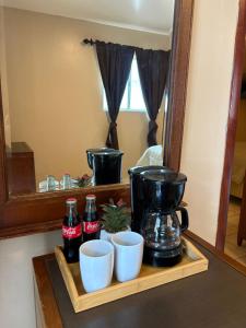 a shelf with a coffee maker and cups and a mirror at Hotel Del Bosque in Tijuana