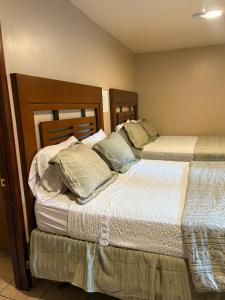 two beds sitting next to each other in a room at Hotel Del Bosque in Tijuana