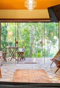 a screened in porch with a table and chairs at Chalé da árvore Buzios in Búzios