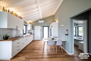 a kitchen with white cabinets and a table and chairs at Beer House by PontaNegraAzores in Altares