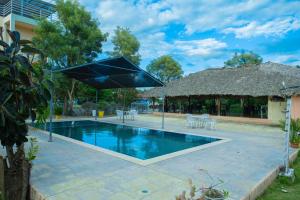 a swimming pool with an umbrella next to a building at Hotel Anedi in Concepción de La Vega