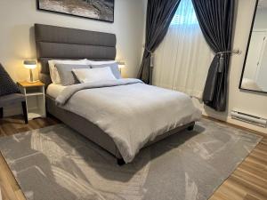 a bedroom with a large bed and a window at 5 Star Suite with Free Parking and Easy Access to Downtown in Calgary