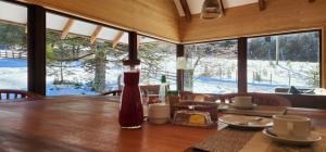 a wooden table with a bottle of sauce on top of it at Cuyul Lodge in Malalcahuello