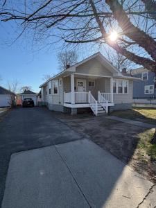 a white house with a car parked in the driveway at Providence Cozy Stays in Providence