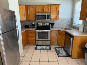 a kitchen with wooden cabinets and a stainless steel refrigerator at Providence Cozy Stays in Providence