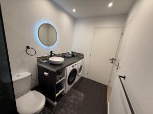 a bathroom with a sink and a washing machine at Cosy home in Saint Martin