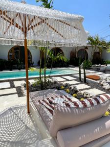 a white umbrella sitting next to a swimming pool at Alma Nusa Penida in Nusa Penida