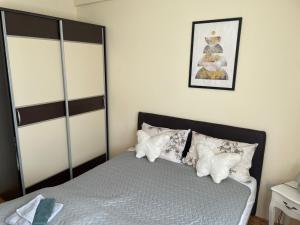 a bedroom with a bed with white pillows at SkyBreak Apartment in Ledine