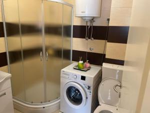 a bathroom with a washing machine and a washer at SkyBreak Apartment in Ledine