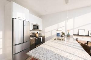 a kitchen with a stainless steel refrigerator and a counter at Charming Walker's Point Apt with Balcony | Sleeps 4 in Milwaukee