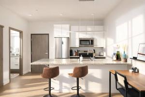 a kitchen with a counter with two bar stools at Charming Walker's Point Apt with Balcony | Sleeps 4 in Milwaukee +8 photos