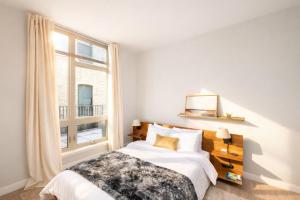 a bedroom with a bed and a large window at Charming Walker's Point Apt with Balcony | Sleeps 4 in Milwaukee
