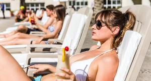 a woman in a bikini sitting in lawn chairs at Rosarito Beach Hotel in Rosarito