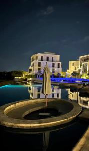 an umbrella in the water in front of a building at Ayla golf in Aqaba