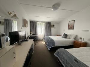 a hotel room with two beds and a television at Motel Bombala in Bombala
