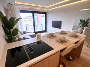 a kitchen with a table and a living room at Luxury apartment with sea view in Westende-Bad