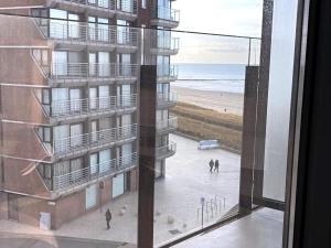 a view of the beach from a window of a building at Luxury apartment with sea view in Westende-Bad