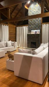 a living room with white couches and a fireplace at Lazer e descanso em Witmarsum in Palmeira