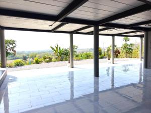 a pavilion with a white tile floor and columns at Phu Man Mhok Khao Yai in Ban Nong Takhain