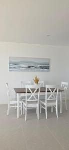 a white dining room with a white table and chairs at Coastal Calm Seascapes unit 3 in Falcon