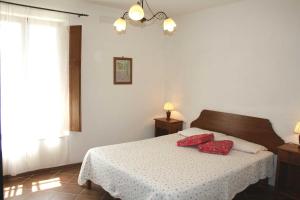 1 dormitorio con 1 cama con 2 almohadas rojas en Agriturismo La Torretta, en Siena