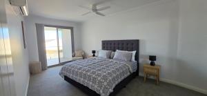 a bedroom with a bed with a ceiling fan at Coastal Calm Seascapes unit 3 in Falcon