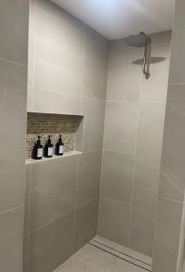 a bathroom with a shower with three bottles on a shelf at Coastal Calm Seascapes unit 3 in Falcon +10 photos